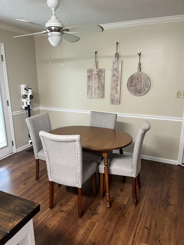 dining room featuring crown molding, dark hardwood / wood-style floors, ceiling fan, and a textured ceiling