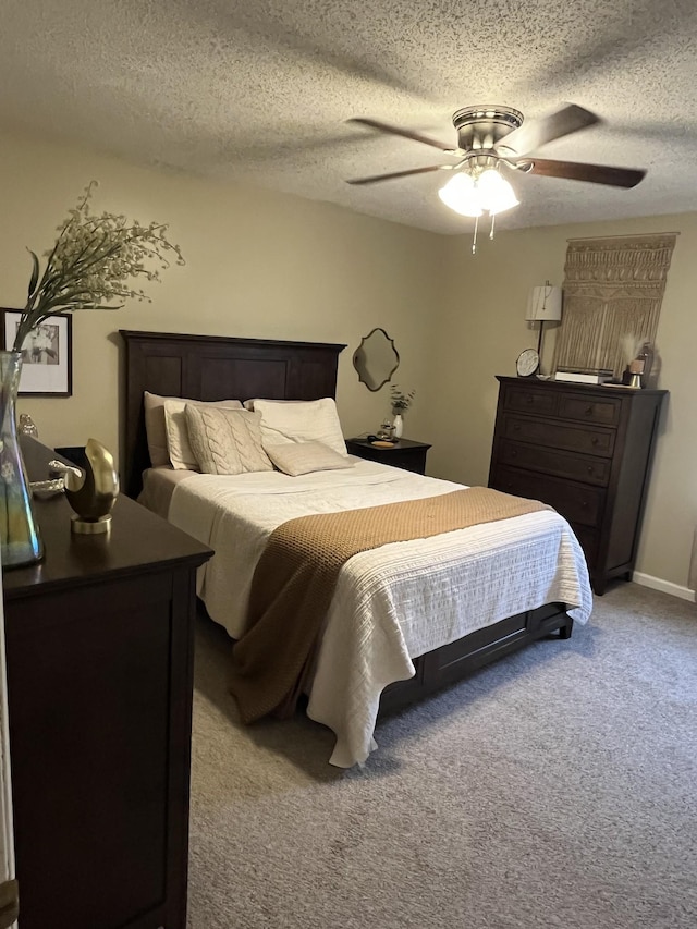 carpeted bedroom featuring a textured ceiling and ceiling fan