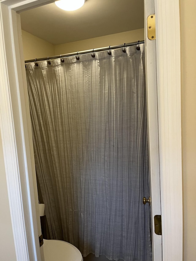 bathroom featuring curtained shower and toilet