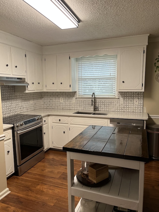 kitchen with dark wood-type flooring, sink, white cabinetry, appliances with stainless steel finishes, and decorative backsplash