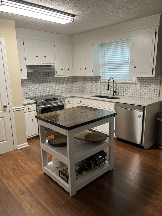 kitchen featuring stainless steel appliances, white cabinetry, sink, and dark hardwood / wood-style flooring