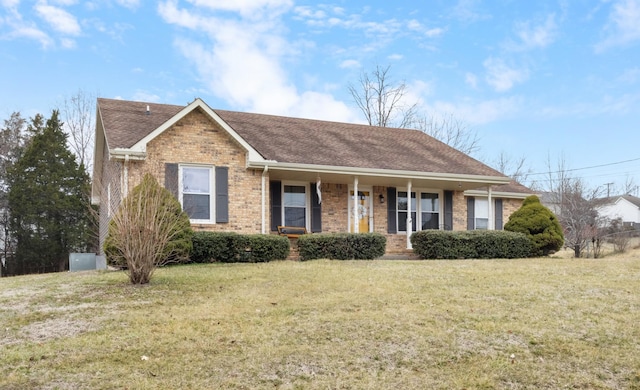 ranch-style house featuring a front lawn and covered porch