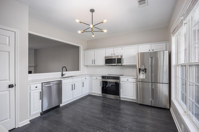 kitchen featuring white cabinetry, sink, pendant lighting, and appliances with stainless steel finishes