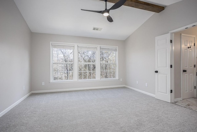 empty room featuring lofted ceiling with beams, plenty of natural light, light carpet, and ceiling fan