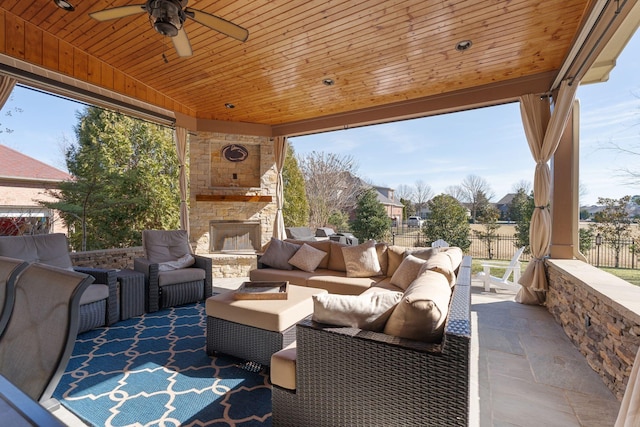 view of patio / terrace featuring ceiling fan and an outdoor living space with a fireplace