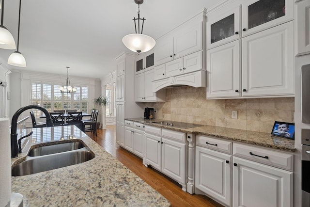 kitchen featuring pendant lighting, white cabinetry, black electric stovetop, and sink