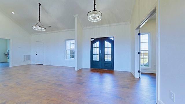 entrance foyer featuring visible vents, ornamental molding, dark wood-type flooring, an inviting chandelier, and french doors