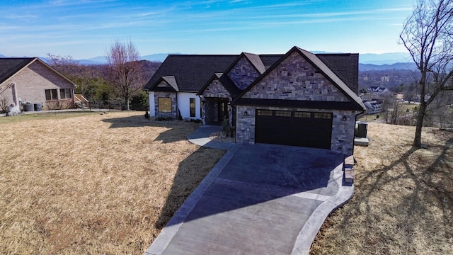 view of front of house with a mountain view, a garage, and a front lawn