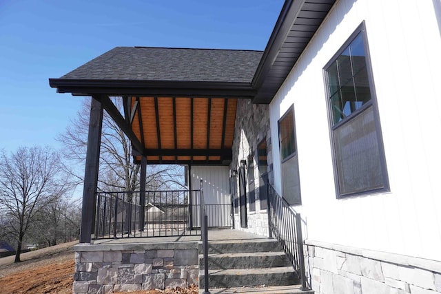 doorway to property featuring roof with shingles