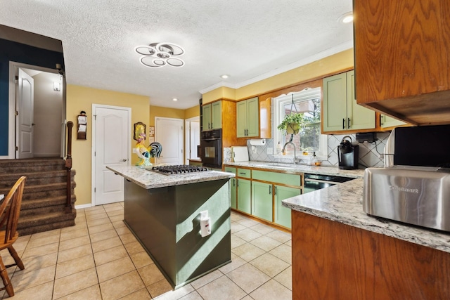 kitchen featuring light stone counters, stainless steel appliances, green cabinetry, and light tile patterned flooring