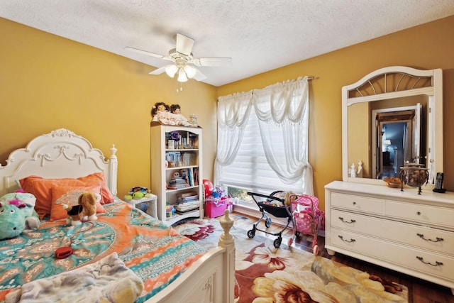 bedroom with hardwood / wood-style floors, a textured ceiling, and ceiling fan