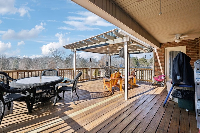 wooden deck with ceiling fan and a pergola