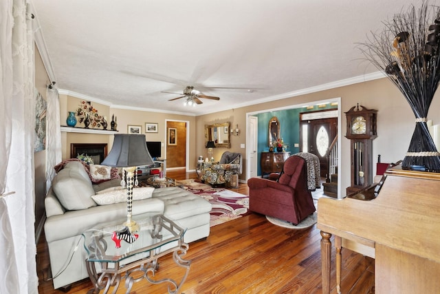 living room featuring hardwood / wood-style floors, ornamental molding, and ceiling fan