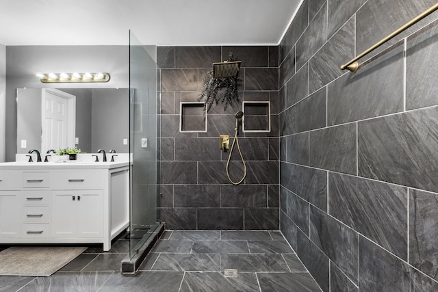 bathroom with vanity and a tile shower