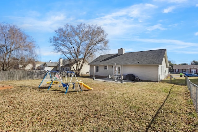 back of property with a yard, a playground, and a patio area