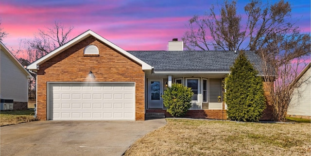 view of front of property featuring a garage and a lawn