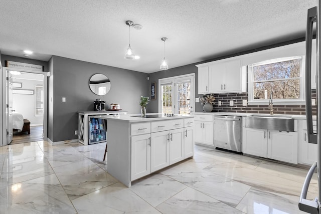 kitchen featuring pendant lighting, sink, white cabinets, a kitchen island, and stainless steel dishwasher