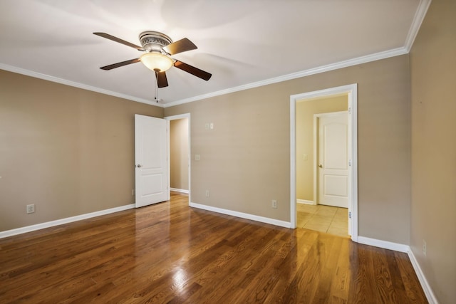 empty room featuring hardwood / wood-style flooring, crown molding, and ceiling fan