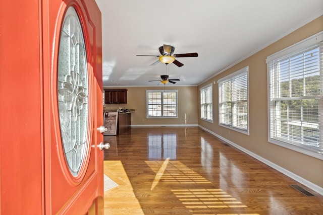 entrance foyer with crown molding and light hardwood / wood-style flooring