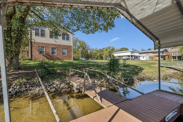 view of dock with a lawn and a water view