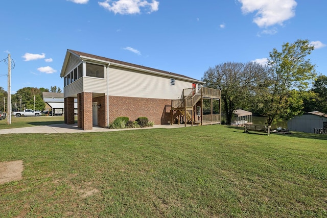 view of home's exterior with a wooden deck, a sunroom, and a yard