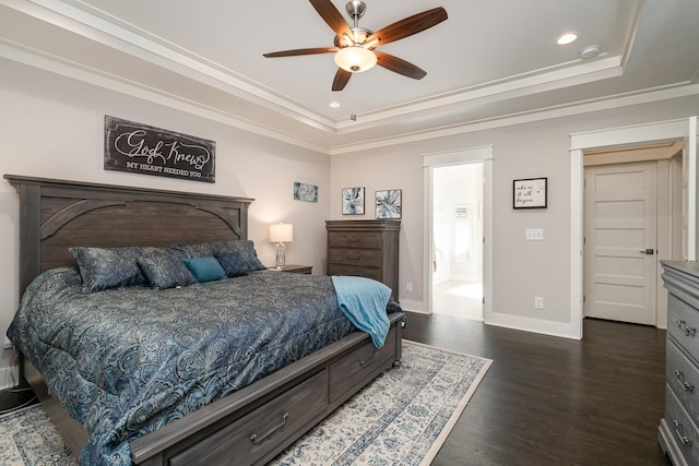 bedroom with dark hardwood / wood-style floors, ceiling fan, ornamental molding, and a tray ceiling