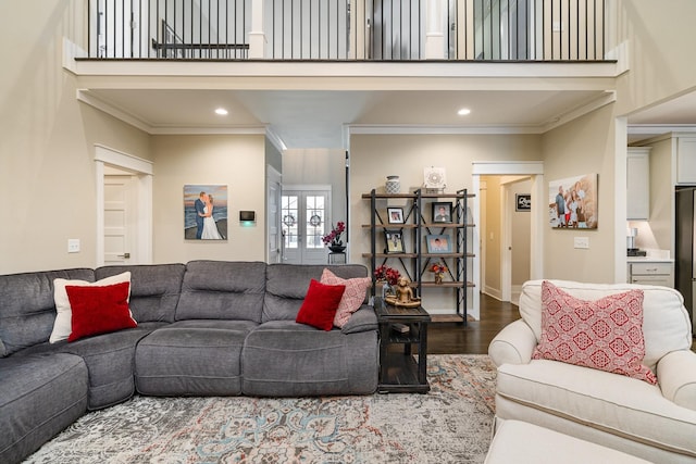 living room with hardwood / wood-style flooring, ornamental molding, and a high ceiling