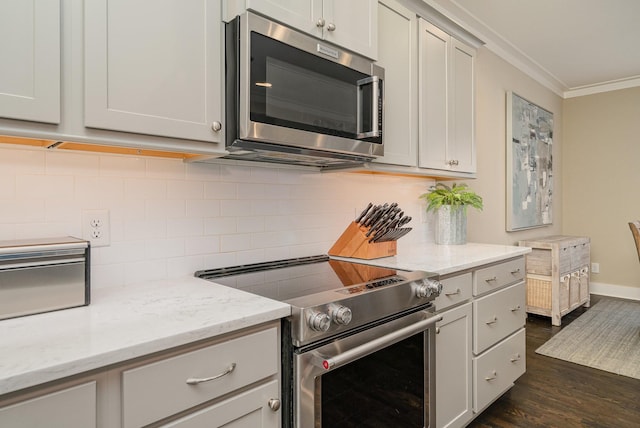 kitchen with dark hardwood / wood-style floors, backsplash, light stone counters, stainless steel appliances, and crown molding