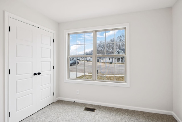 empty room with plenty of natural light and carpet floors