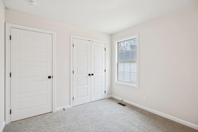 unfurnished bedroom featuring carpet flooring and a closet