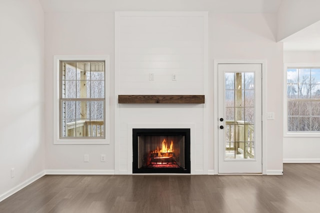 unfurnished living room featuring hardwood / wood-style flooring and a large fireplace