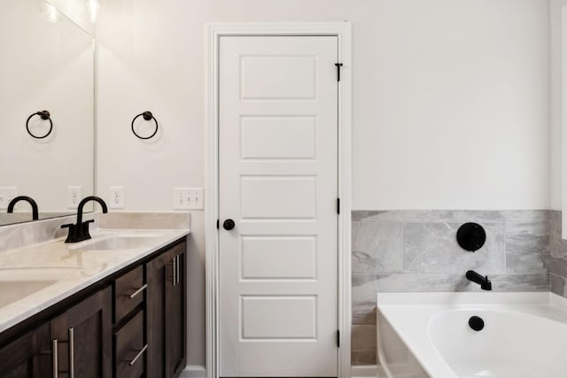 bathroom featuring vanity and a tub