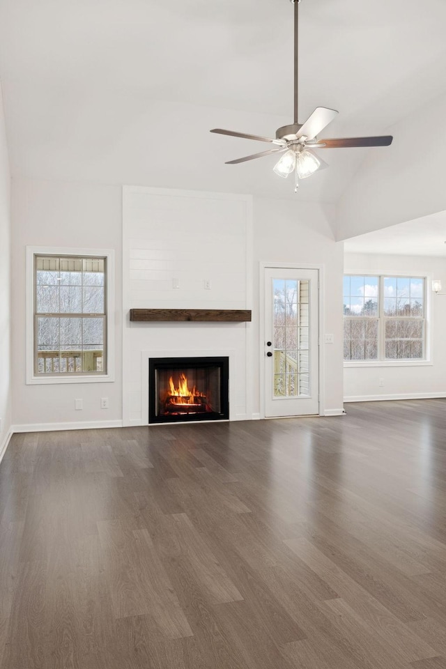 unfurnished living room with vaulted ceiling, dark hardwood / wood-style floors, and ceiling fan