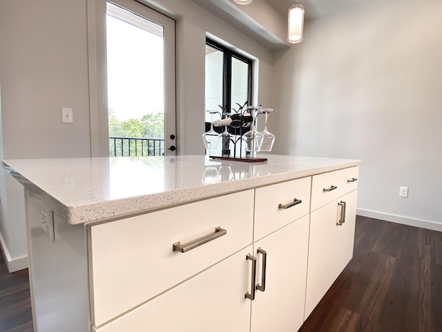 interior space featuring white cabinetry, light stone counters, and dark hardwood / wood-style flooring