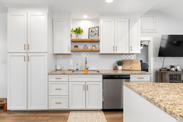 kitchen with dishwasher, sink, white cabinets, light stone counters, and light hardwood / wood-style floors