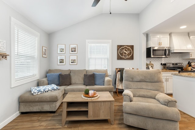 living room with vaulted ceiling, ceiling fan, plenty of natural light, and hardwood / wood-style floors