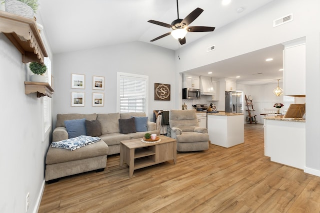 living room with lofted ceiling, ceiling fan, and light hardwood / wood-style flooring