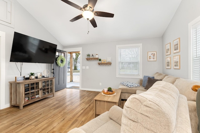 living room with lofted ceiling, a wealth of natural light, light hardwood / wood-style floors, and ceiling fan