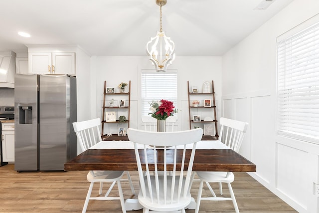 dining room featuring an inviting chandelier and light hardwood / wood-style flooring