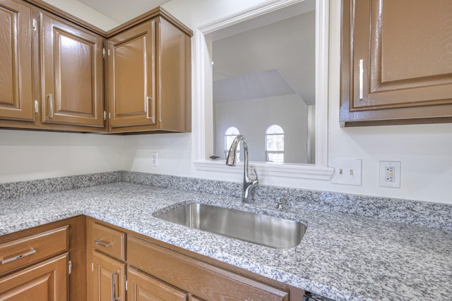 kitchen featuring sink and light stone countertops