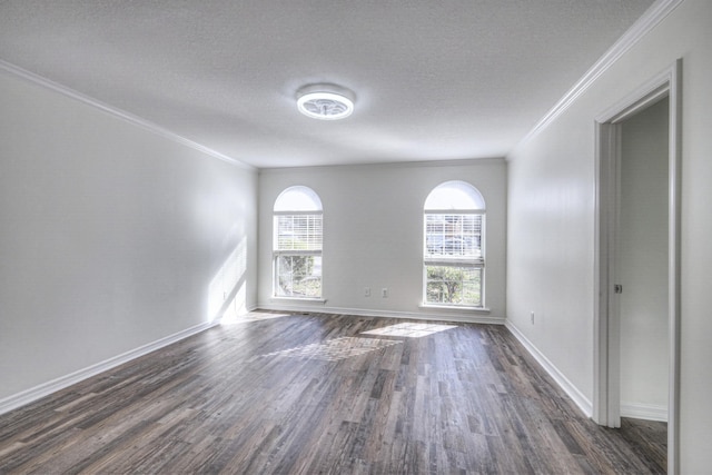 empty room with ornamental molding, dark hardwood / wood-style floors, and a textured ceiling