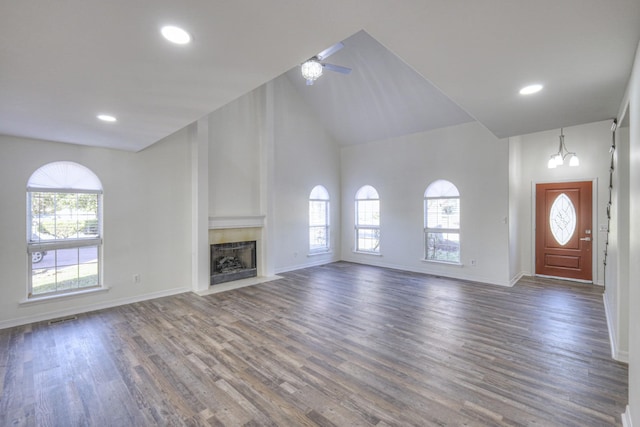 unfurnished living room featuring a healthy amount of sunlight, dark hardwood / wood-style floors, and high vaulted ceiling