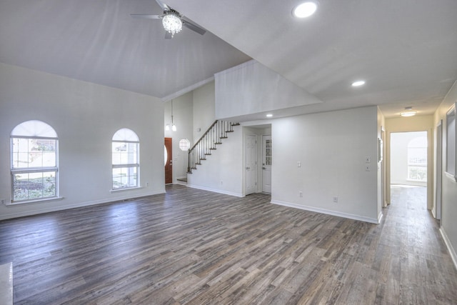 unfurnished living room featuring dark wood-type flooring, ceiling fan, and a high ceiling