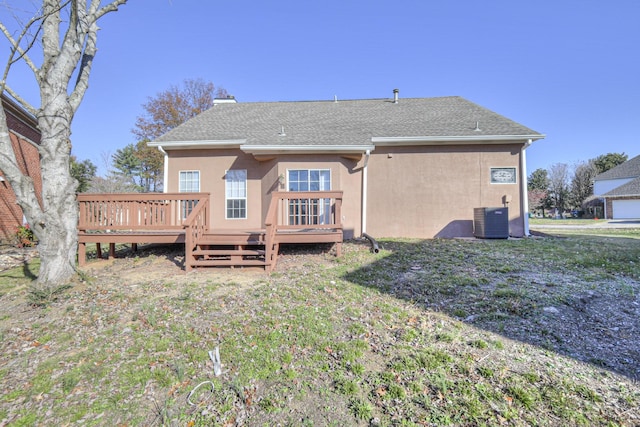 rear view of property with central AC unit, a yard, and a deck