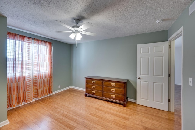 bedroom featuring ceiling fan, a textured ceiling, and light wood-type flooring