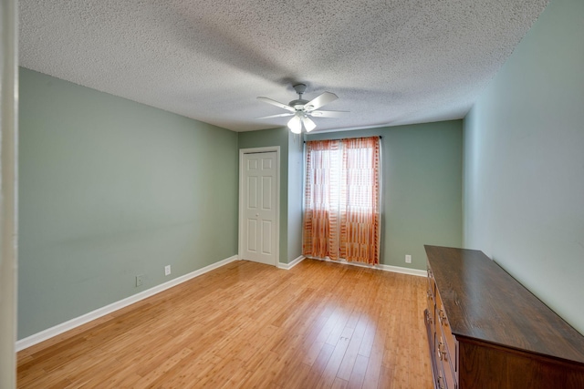 unfurnished bedroom with ceiling fan, a textured ceiling, light wood-type flooring, and a closet