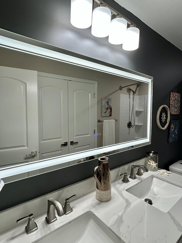 bathroom with vanity, toilet, and a shower