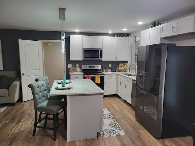 kitchen featuring range with electric stovetop, a kitchen island, decorative light fixtures, white cabinetry, and fridge with ice dispenser