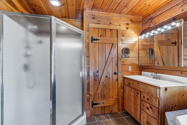 bathroom featuring tile patterned floors, a shower with shower door, wooden ceiling, vanity, and wooden walls