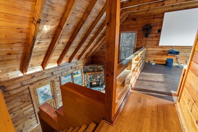 interior space featuring wood ceiling, wood-type flooring, wooden walls, and lofted ceiling with beams